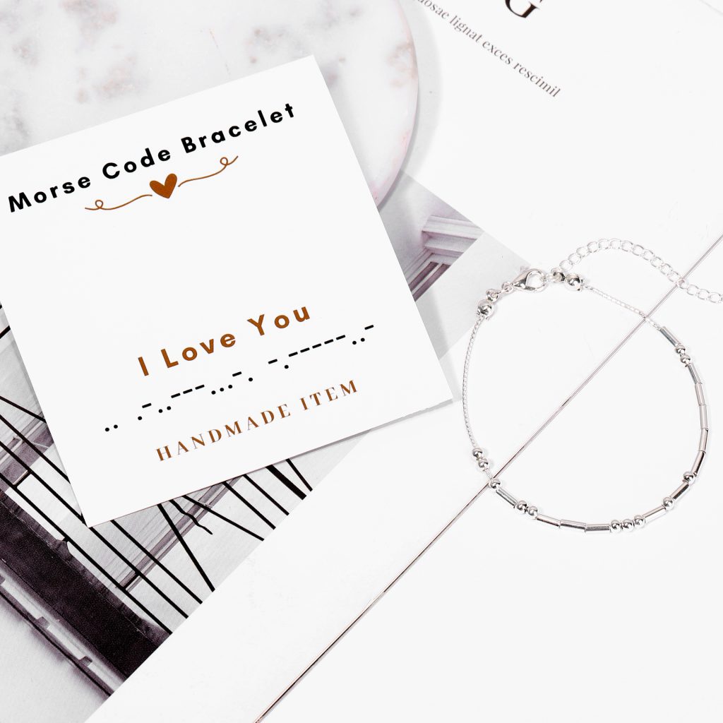 Silver Morse Code bracelet displayed with a message card reading “I Love You,” showing dot and dash pattern for personalized handmade jewelry.